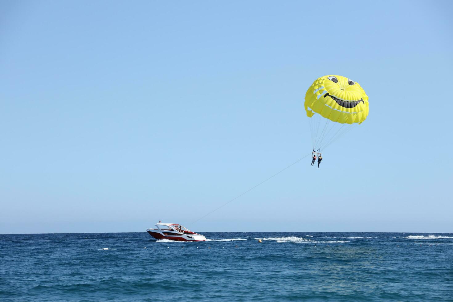 ANTALYA, TURKEY - MAY 15, 2021 Parasailing in a blue sky near sea beach. Parasailing is a popular recreational activity among tourists in Turkiye photo