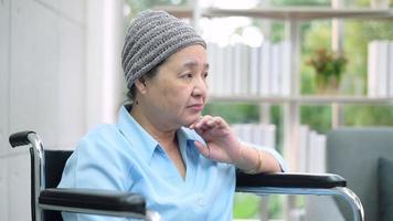 Depressed and hopeless Asian cancer patient woman wearing head scarf in hospital. video