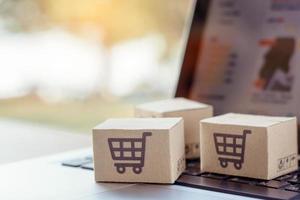 Shopping online. Cardboard box with a shopping cart logo on laptop keyboard. Shopping service on The online web. offers home delivery photo