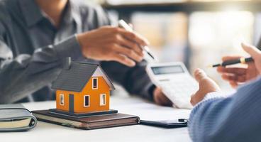 Real estate agent talked about the terms of the home purchase agreement and asked the customer to sign the documents to make the contract legally, Home sales and home insurance concept. photo