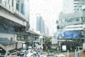 Morning city,view through the window on rainy day. Water droplets on the glass on a rainy day. rain drops during raining in rainy day outside window glass with blurred background. photo