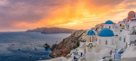 Oia at sunset, Santorini island, Greece. Artistic sunset landscape with beautiful panorama and sun rays sea view. Fantastic summer vacation and holiday concept. Peaceful nature scenery photo