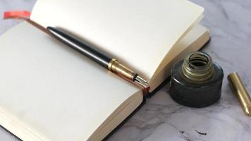Fountain pen on blank notebook with inkwell video