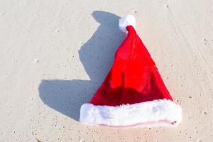 Close up Santa hat on a white sandy beach photo
