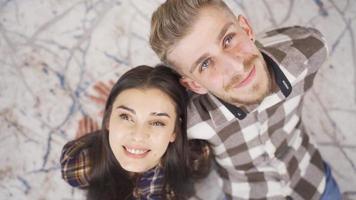 feliz jovem casal olhando às a céu, sonhando acordado, tendo dificuldade. encantador lindo jovem mulher e bonito jovem homem sonhando juntos olhando para dentro a céu. video