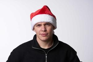 man in santa hat close-up light background holiday photo