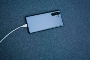 Mobile smart phones charging on gray background photo