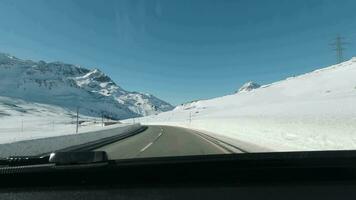 dirigindo carro perto Bernina passar dentro Suíça dentro inverno. suíço Alpes. neve e montanhas video