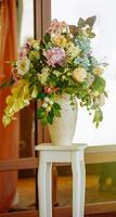 Decoration flowers in a vase on a stand photo