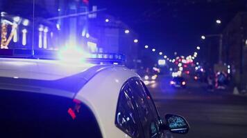 polizia auto luci tremolante nel notte città con selettivo messa a fuoco e bokeh video