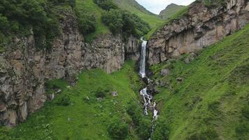 Aerial zoom in view Arsha waterfall stream in green caucasus mountains. KAzbegi national park. Things to see and do. Popular sightseeing hiking attraction. Georgia travel destination concept video