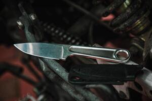 A knife with a metal handle made from a wrench. Tool weapon. Motorcycle engine on the back. photo