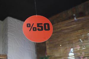 A striking 50 Sale Discount Sign prominently displayed in a retail shopping setting photo