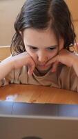 vertical pequeño niña acecho dibujos animados en ordenador portátil video
