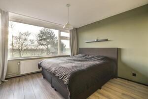 A bedroom with a bed and a window photo