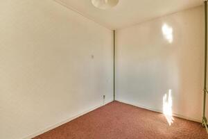 An empty room with a light shining through the window photo