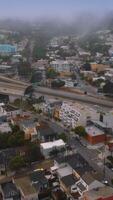 bezig verkeer door de ingewikkeld systeem van wegen in san francisco. stedelijk panorama geleidelijk aan het bedekken met wit mist. antenne visie. verticaal video