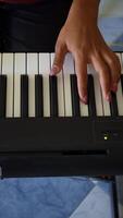 vrouw spelen digitaal synthesizer binnen. detailopname. hoog hoek schot. verticaal video