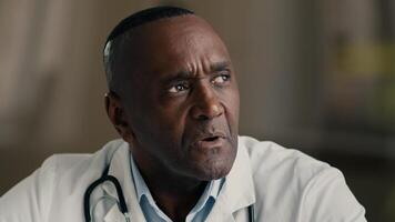 Puzzled thoughtful senior male professional medic mature adult doctor african american man in medical coat planning idea brainstorming thinking thoughts contemplating healthcare and medicine concept photo