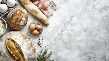 Various types of bread, eggs and other ingredients on a marble counter photo