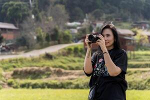 Woman photographer with big backpack taking photo of mountains and blue lake. Travel and hobby concept.