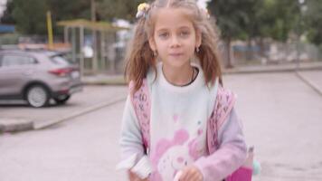contento pequeño Chica de escuela con mochila caminando en calle video