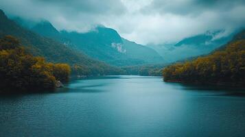 Lush Mountain Landscape with Overcast Sky Reflecting on Teal Lake Water with Dense Forest and Cliffs in an Outdoor Scenic Environment photo