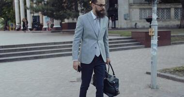uma à moda homem de negocios caminhando com confiança dentro uma movimentado cidade configuração durante a dia video