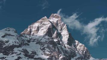Aerial view of Cervino Ski Paradise and Cervino town with the Matterhorn's snow covered peaks, drifting clouds, and sweeping camera motion. video
