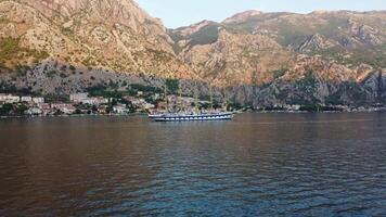 kotor, Montenegro, 27/08/2024, pôr do sol panorama do a real tosquiadeira Navegando navio dentro a baía do kotor dentro a mar entre a montanhas. zangão Visão do usava cruzeiro navio viagem e feriados video