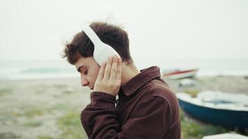 man känsla fri medan lyssnande till musik på de Strand under vinter- video