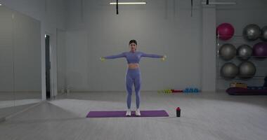 desportivo menina noivando dentro ombro exercícios dentro uma moderno Academia configuração durante luz do dia horas video